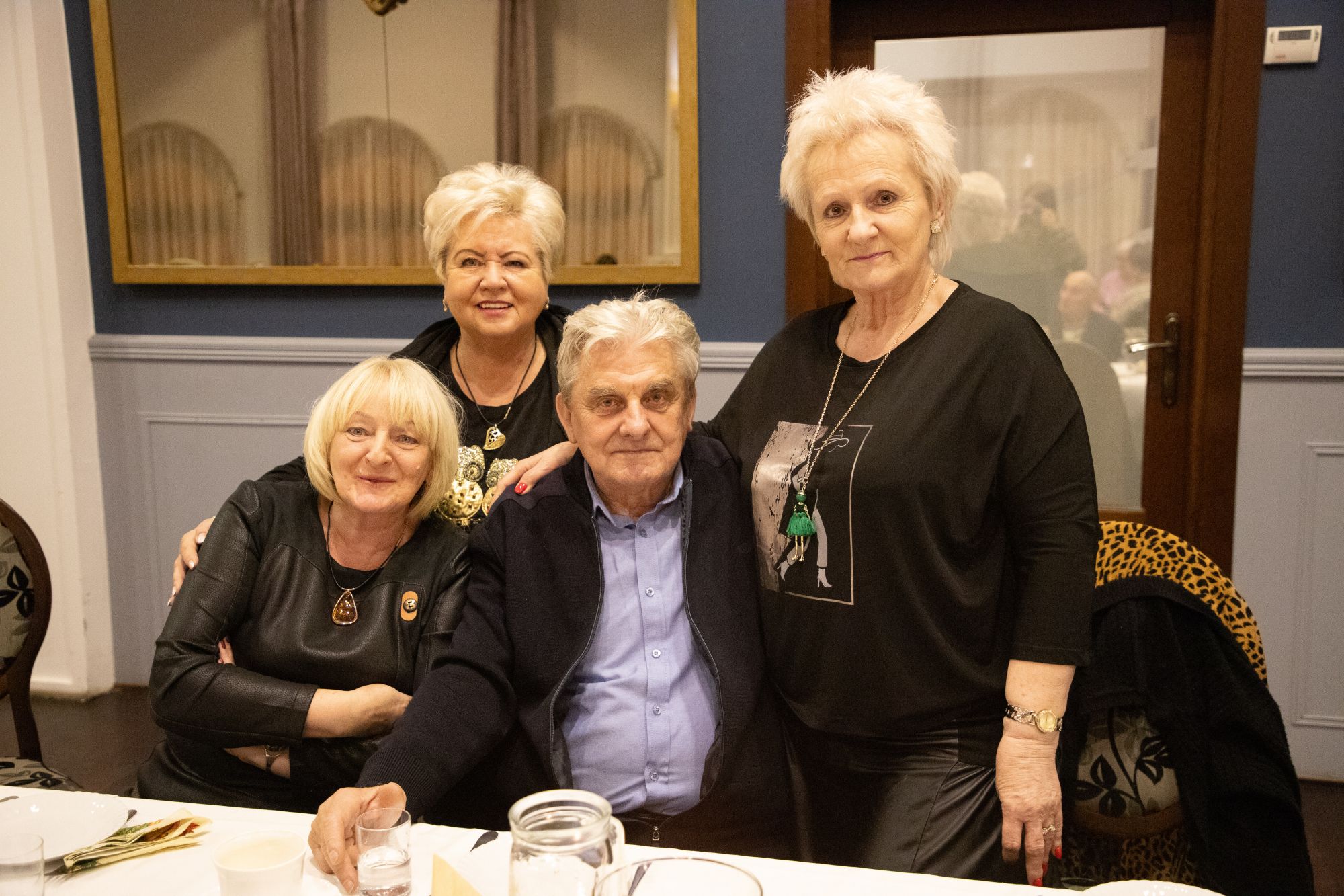 Czterech seniorów siedzących przy stole: mężczyzna i trzy kobiety